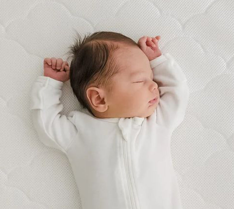 image of a baby sleeping to a newton mattress