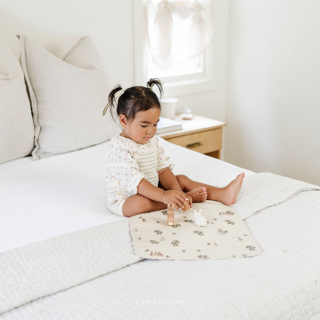 Image of a small girl playing with toys in bed